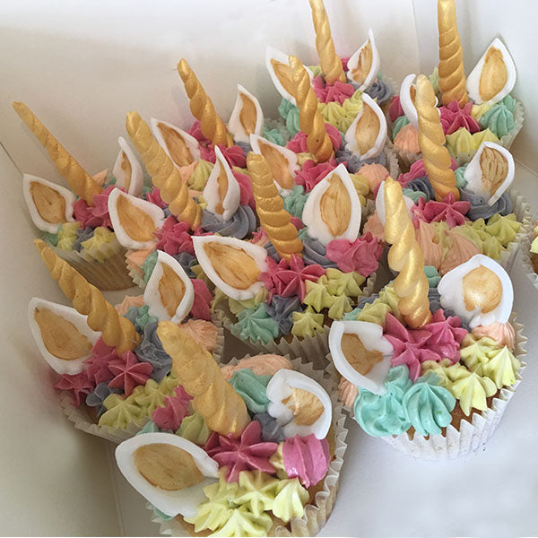 Bright Colourful Rainbow Cupcakes decorated with fondant horns and ears.