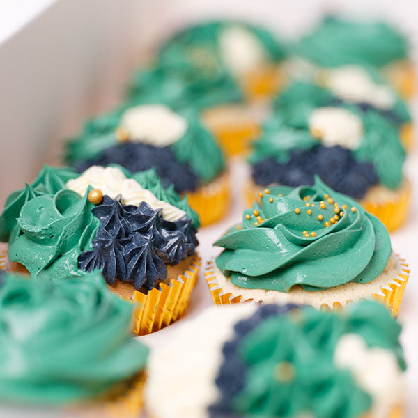Cupcakes decorated with Navy Blue, Emerald Green and Ivory Buttercream, topped with mini edible gold balls.