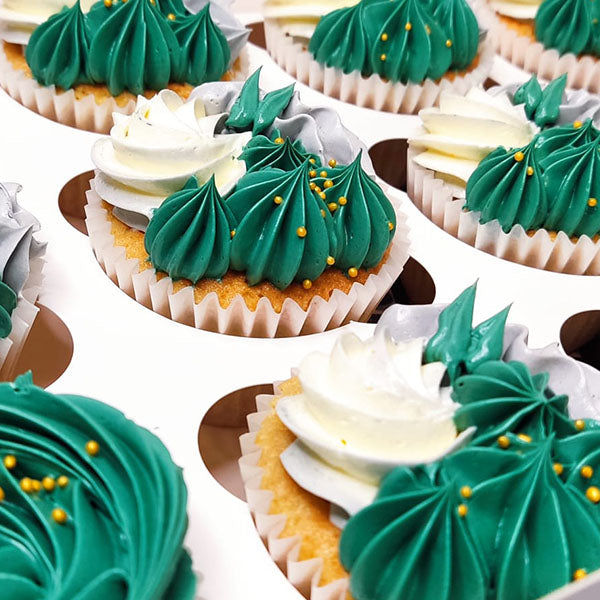 Emerald Green Buttercream piped onto delicious vanilla cupcakes with swirls of vanilla buttercream. Topped with mini edible gold balls.