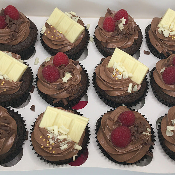 Velvety Chocolate Buttercream Cupcakes topped with Fresh Raspberries and White Chocolate Chunks.